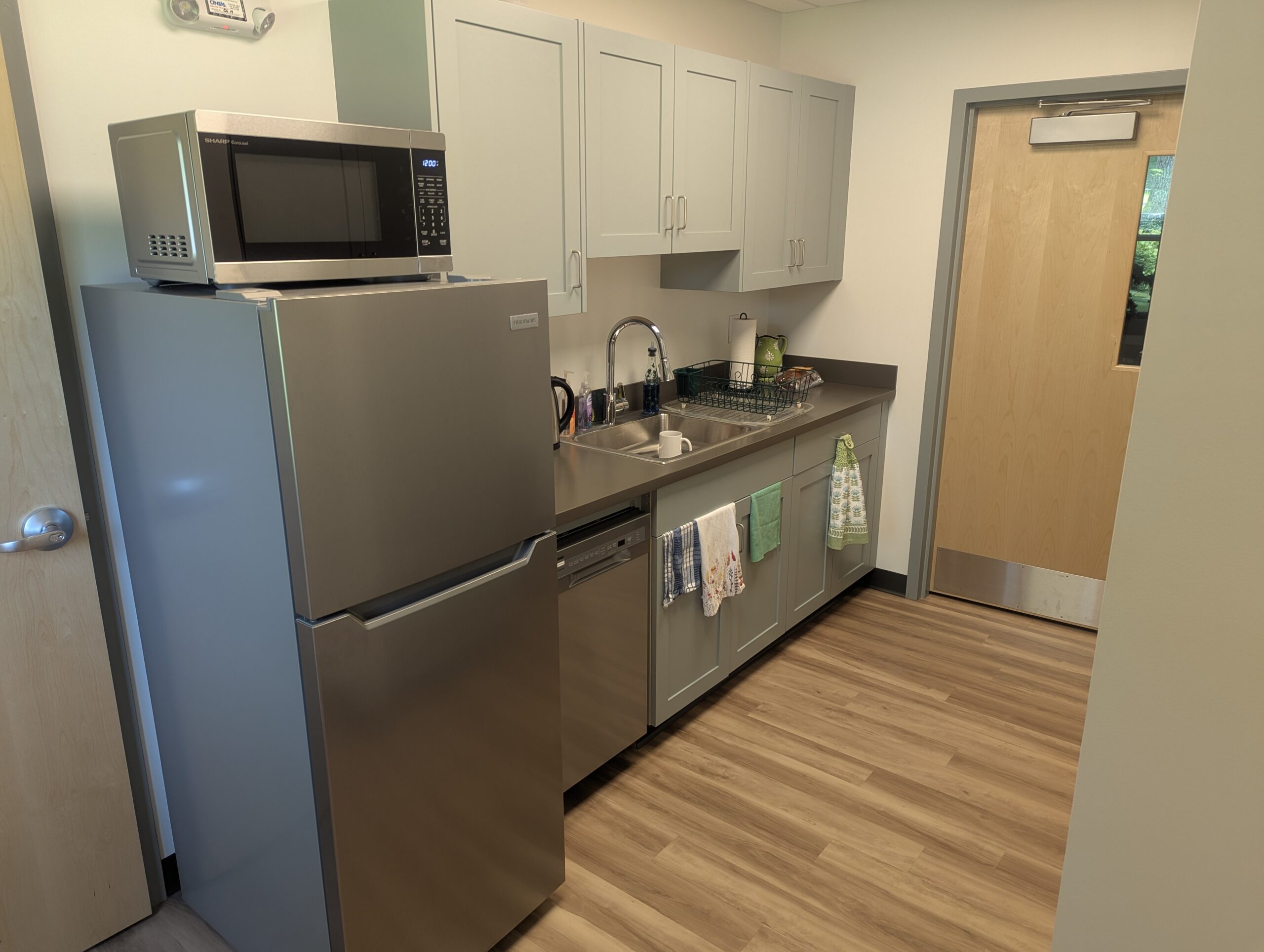 Kitchenette with small fridge and dishwasher